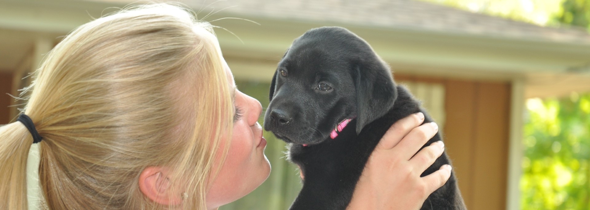 girl kissing puppy